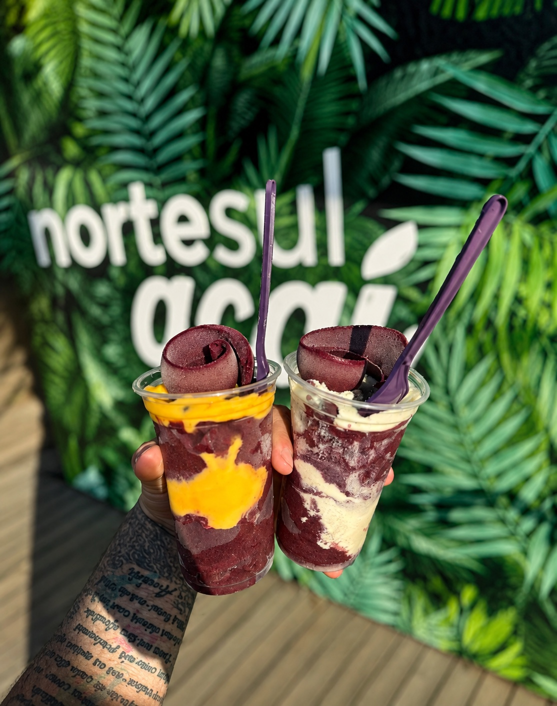 Dois copos de açaí Norte Sul, um com creme de maracujá e outro com creme branco